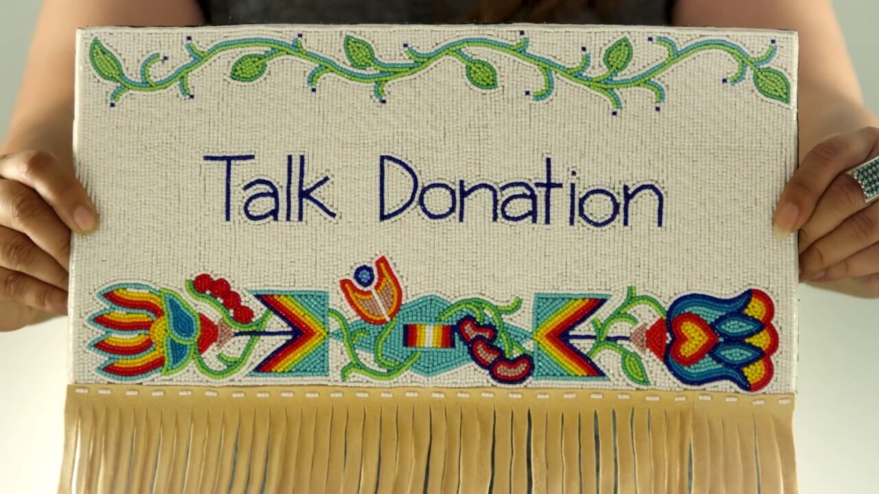 VIdeo poster image featuring a woman holding Native American art with beatiful beadwork that says Talk Donation